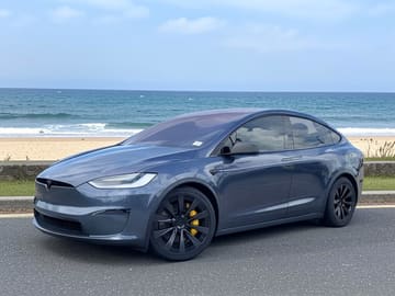 The same vehicle rendered against the coastal road backdrop